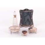 A small collection of silver dressing table items including a cartouch topped trinket box.