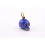 An unusual enamel and ruby skull pendant, the silver mount enamelled in blue, the eye sockets set