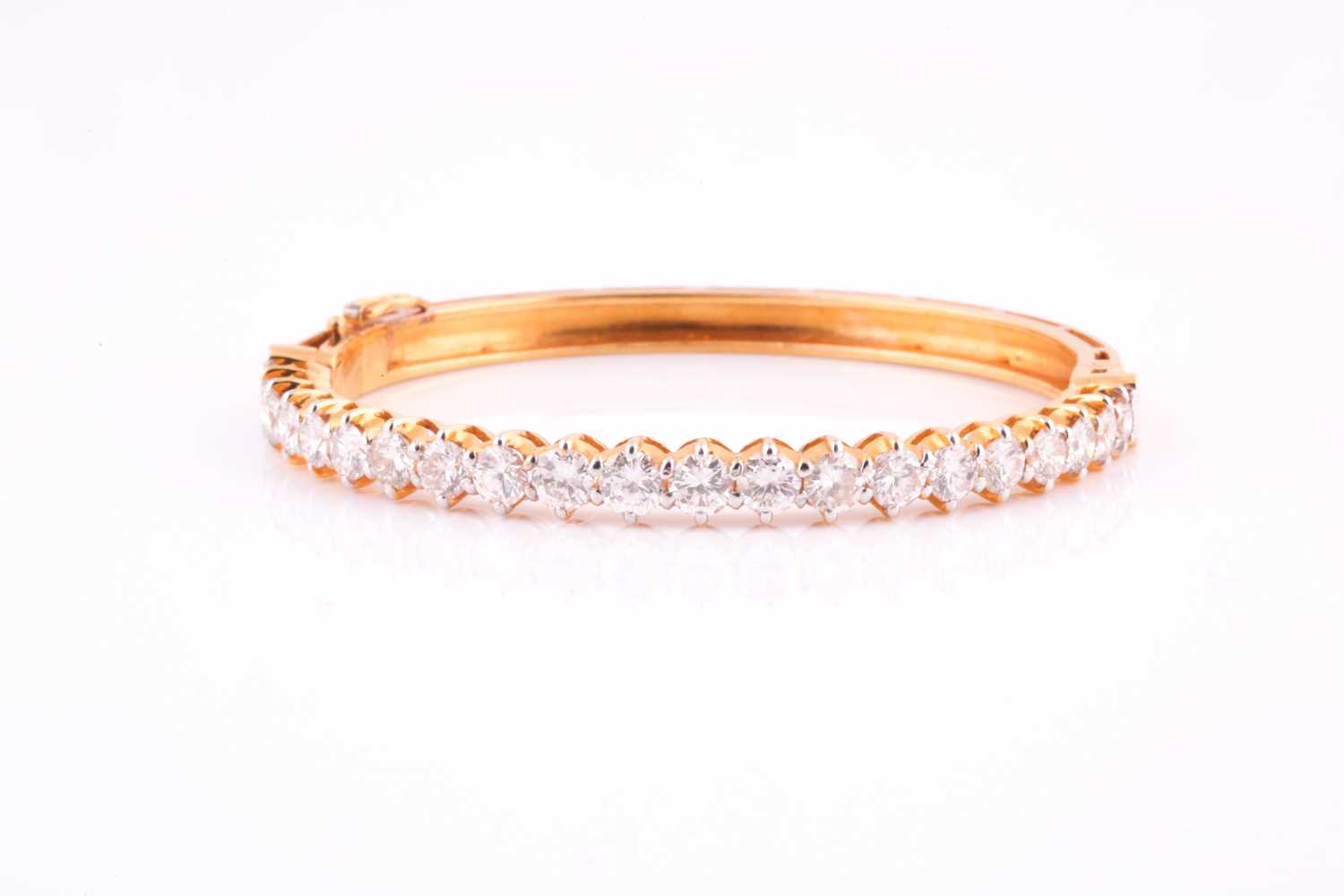 A diamond bangle; the centre set with twenty one graduated round brilliant cut diamonds in claw