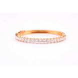 A diamond bangle; the centre set with twenty one graduated round brilliant cut diamonds in claw