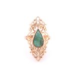 A single stone emerald ring; the pear-shaped emerald in rub over mount within an open scroll work