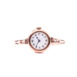 A ladies yellow metal cocktail watch, the round white dial with black Arabic numerals, on
