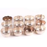 A set of twelve Middle Eastern circular white metal bowls, impressed marks, with scrolled rims,
