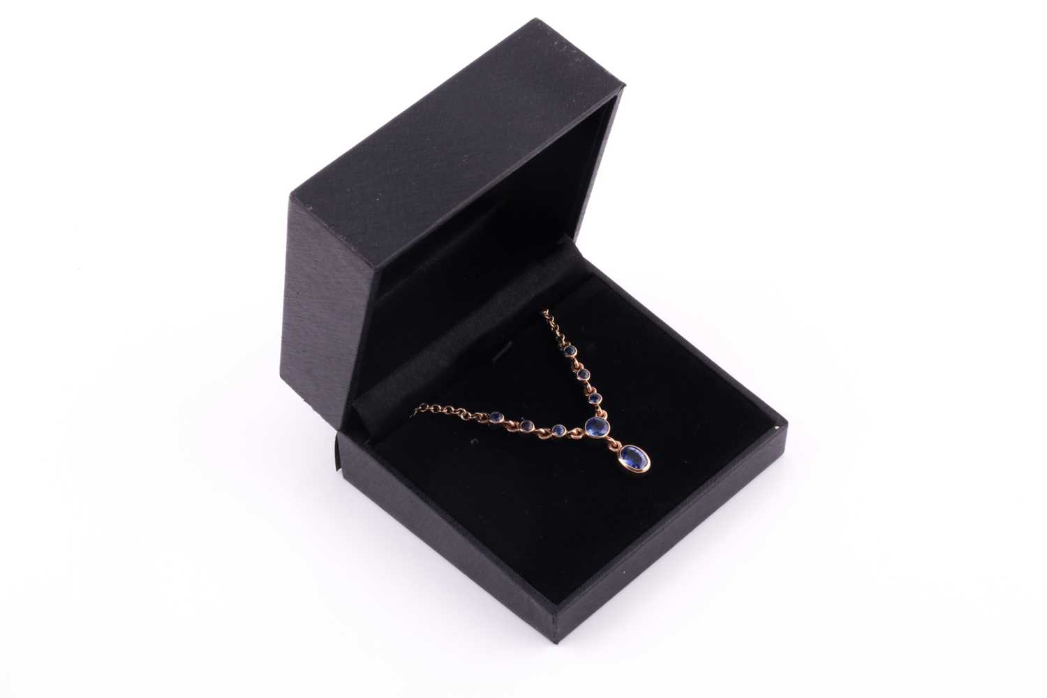 A 9ct yellow gold and blue sapphire drop pendant necklace, set with a mixed oval-cut sapphire - Image 4 of 4