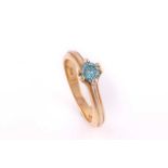 A single stone blue diamond ring; the round brilliant cut diamond in bi-coloured six claw mount, the