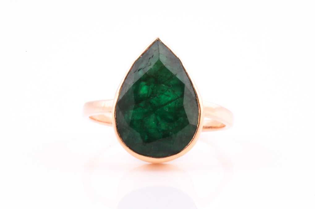 A single stone emerald single stone ring, the faceted pear-shaped emerald in rub-over mount to a