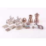 A small group of silver items, comprising a pair of miniature toast racks, a pair of pepper grinders