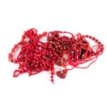 A large quantity of coral necklaces of beaded and natural form together with other glass and