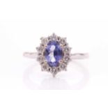 An 18ct white gold, diamond, and tanzanite cluster ring, set with a mixed oval-cut tanzanite,