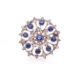 A diamond and sapphire circular brooch, set with round-cut sapphires, each measuring approximately