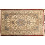An ivory ground Isfahan rug with a barbed central lozenge on an Arabesque field with palmetted