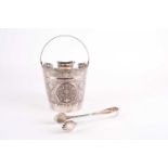 An Indo-Persian silver swing-handle ice bucket, with extensive embossed floral design, 23 cm high (