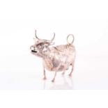 A silver cow creamer, bearing import marks for Chester, 1900, standing four square with a looped