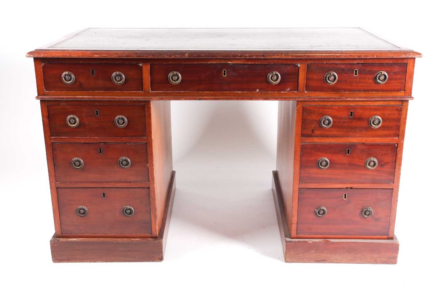 An Edwardian mahogany kneehole writing desk. With tooled leather inset top above six pedestals and