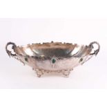 A large oval Continental silver basket, (800 Standard), with scroll handles and set with green