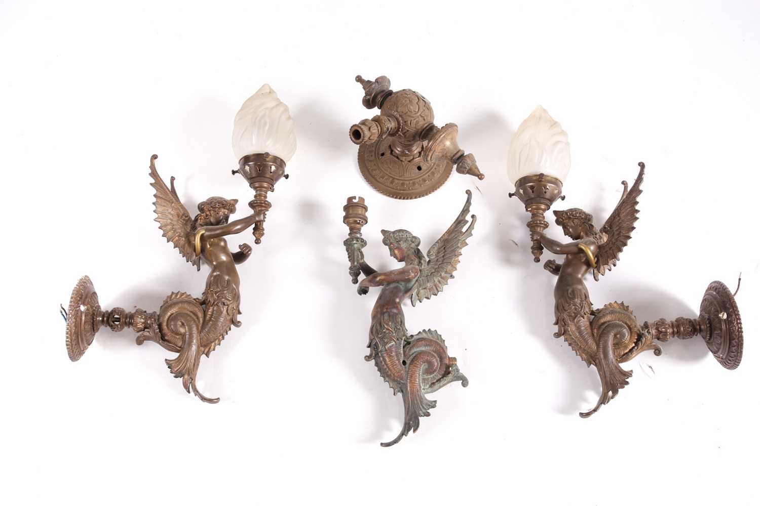 A set of three bronze wall sconces, formed as mythical winged figures, two with globes, 43 cm