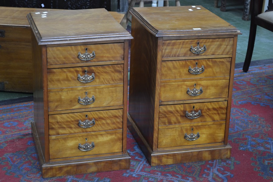 A pair of satinwood bedside chests of three graduated drawers, the second and third drawers with