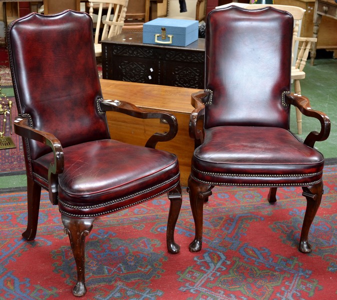 A pair of 20th Century mahogany ox blood leather boardroom elbow chairs, cabriole legs. Mid 20th