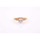 An 18ct yellow gold solitaire round brilliant-cut diamond ring, with three brilliant-cut diamonds