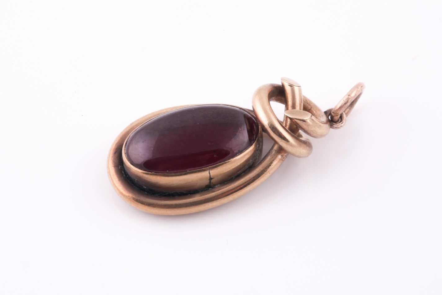 A Victorian yellow metal pendant, the twisted mount set with a cabouchon garnet, with vacant glass - Bild 2 aus 3