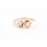 An 18ct yellow gold and diamond crossover ring, set with two round brilliant-cut diamonds of