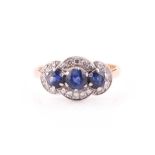 An 18ct yellow gold, diamond, and sapphire triple cluster ring, set with three round-cut sapphires