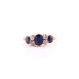 A yellow metal, sapphire and diamond ring, set with three mixed oval-cut sapphires and four round-