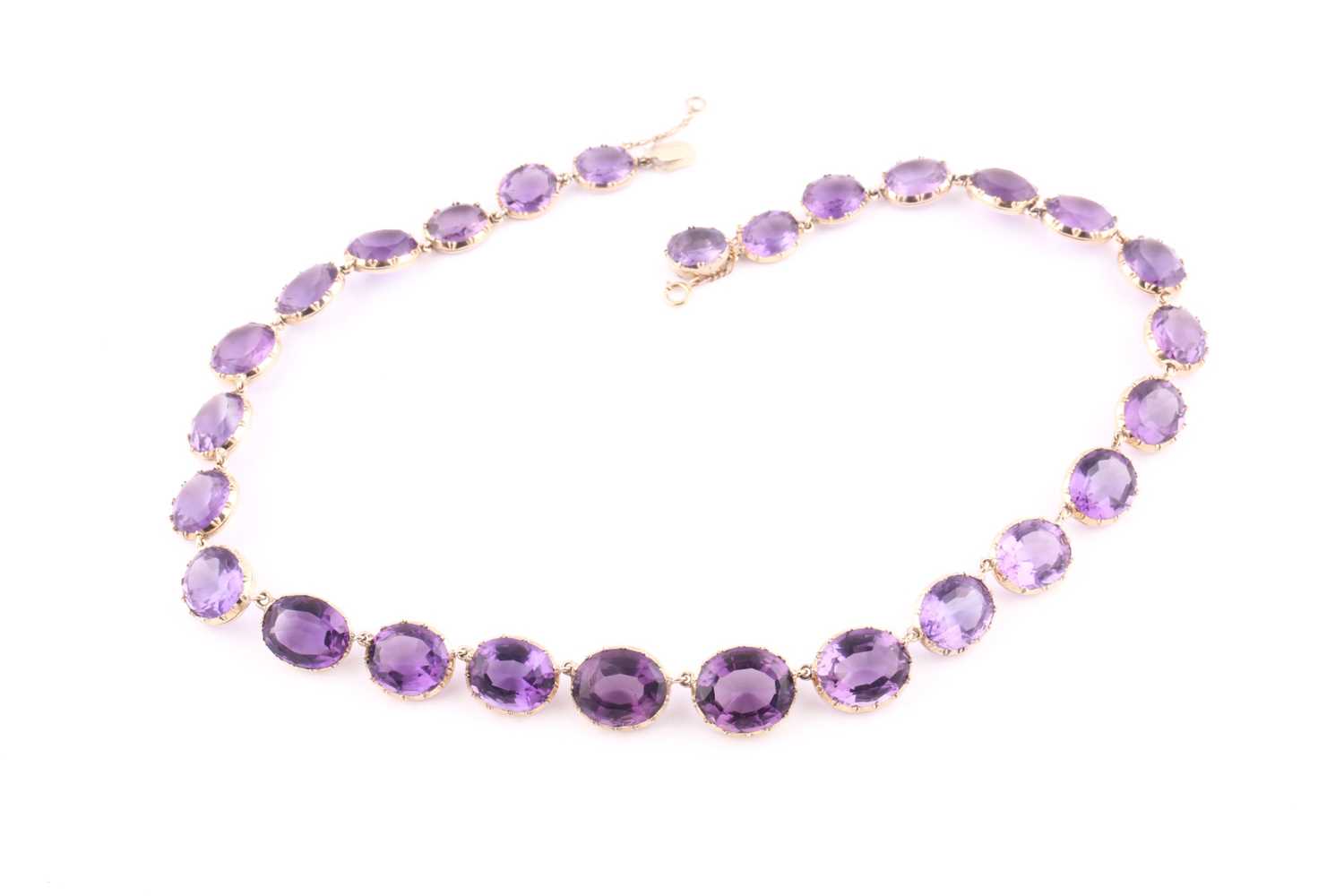 A 19th century style amethyst riviere necklace, set with mixed oval-cut amethyst, claw-set in yellow