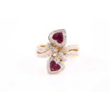 An 18ct yellow gold, diamond, and ruby ring, the crossover style mount with calibre-set ruby hearts,