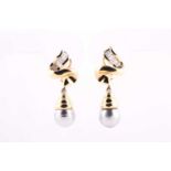 A pair of yellow metal, diamond, and grey pearl earrings, each ribbon-twist mount channel-set with