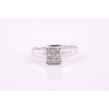 An 18 ct white gold diamond dress ring, illussion set with nine princess-cut diamonds, ring size O