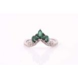 An emerald and diamond ring; the 'V' shaped centre set with five graduated marquise-shaped