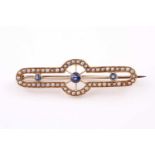 An Edwardian yellow metal sapphire and seed pearl brooch, set with three round rose-cut sapphires,