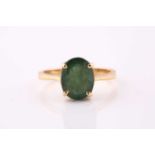 A single stone emerald ring; the oval cut emerald in simple four claw mount to a plain yellow