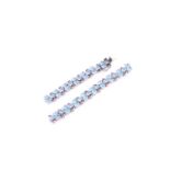 A white metal, blue topaz and ruby bracelet, set with mixed oval-cut blue stones and smaller round-