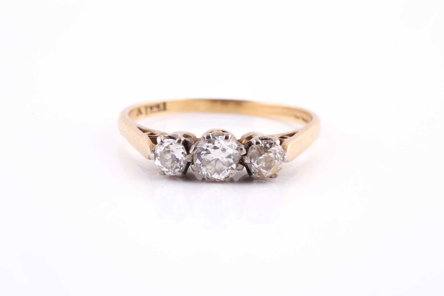 An 18ct yellow gold and diamond ring, set with three old round-cut diamonds, the central stone