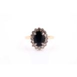 An 18ct yellow gold, diamond, and sapphire cluster ring, set with a mixed oval-cut dark blue