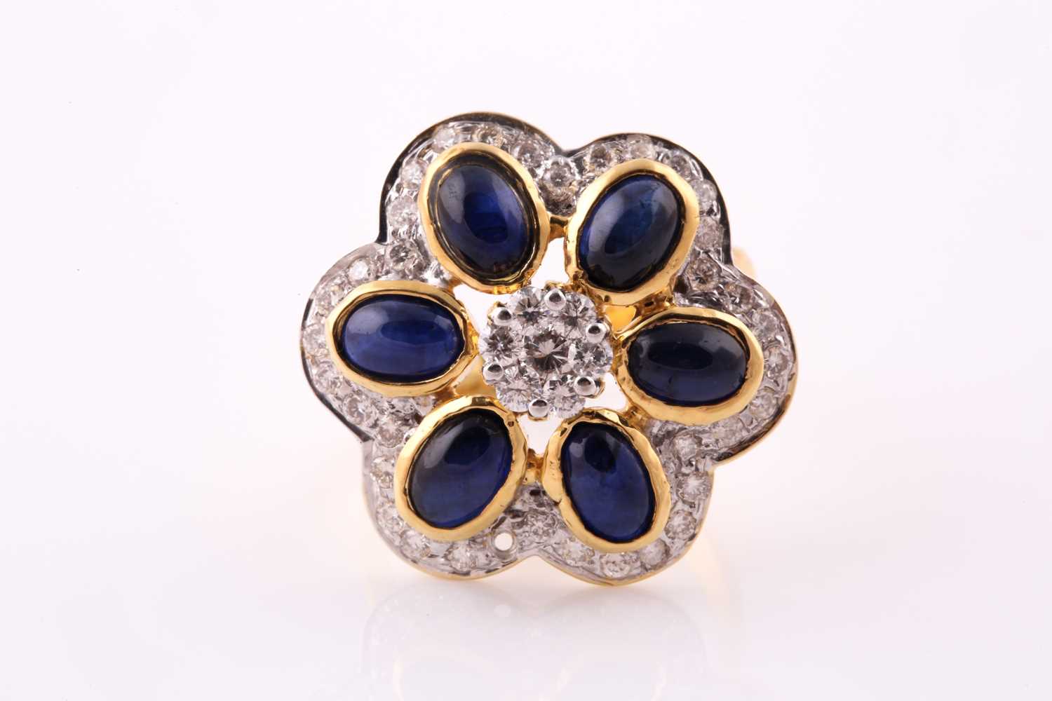 A sapphire and diamond foliate cluster ring; composed of a central seven stone round brilliant cut