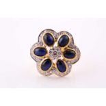 A sapphire and diamond foliate cluster ring; composed of a central seven stone round brilliant cut
