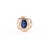 An 18ct yellow gold, diamond, and sapphire ring, set with a mixed oval-cut sapphire, measuring