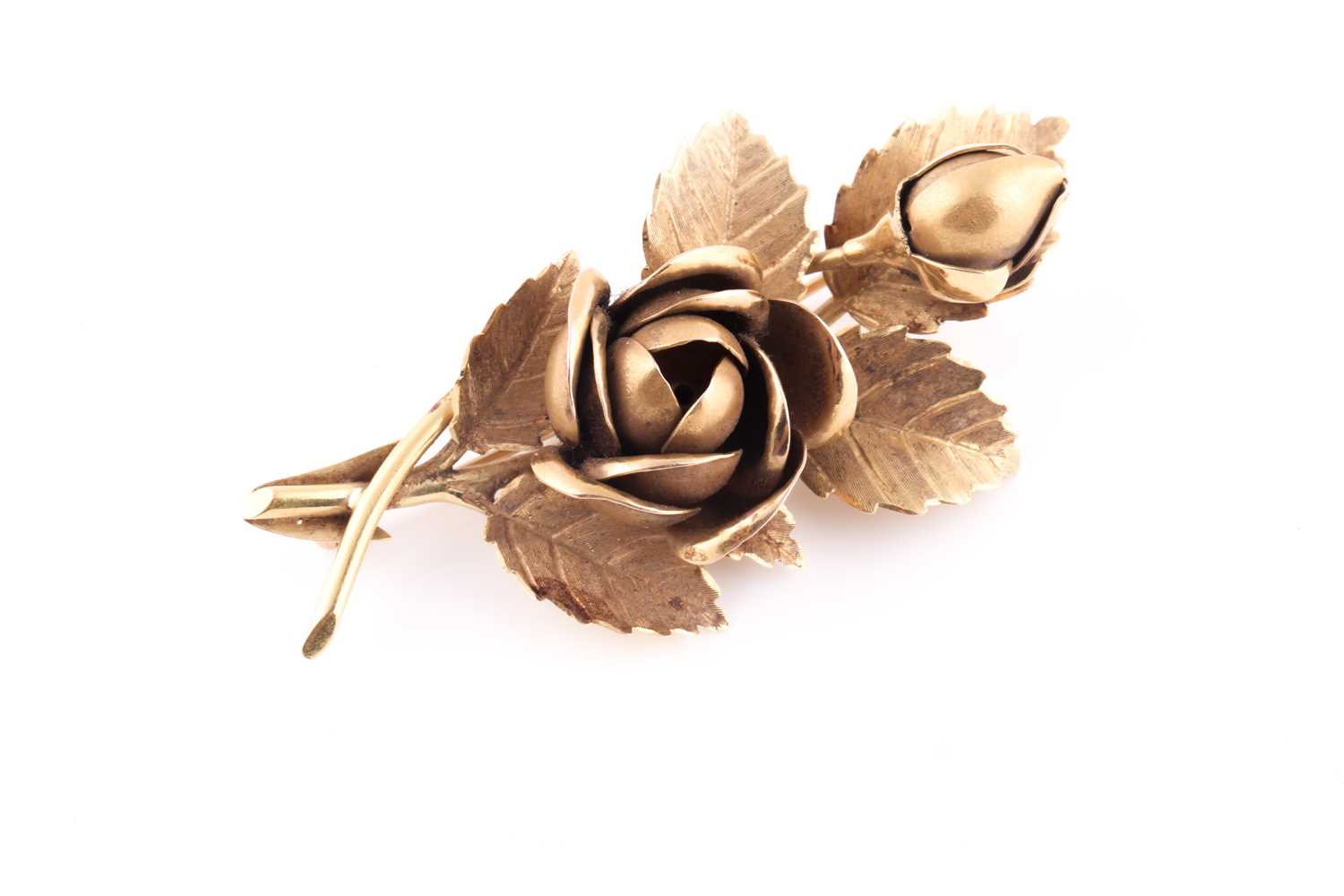 An 18ct yellow gold floral spray brooch, in the form of a rose and bud amongst leaves, marked to