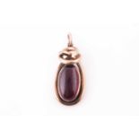 A Victorian yellow metal pendant, the twisted mount set with a cabouchon garnet, with vacant glass