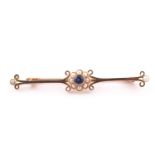 A 15ct yellow gold, sapphire, and pearl bar brooch, set with floral cluster to centre and a pearl to