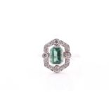 A platinum, diamond, and emerald ring, set with an emerald-cut emerald of approximately 1.0