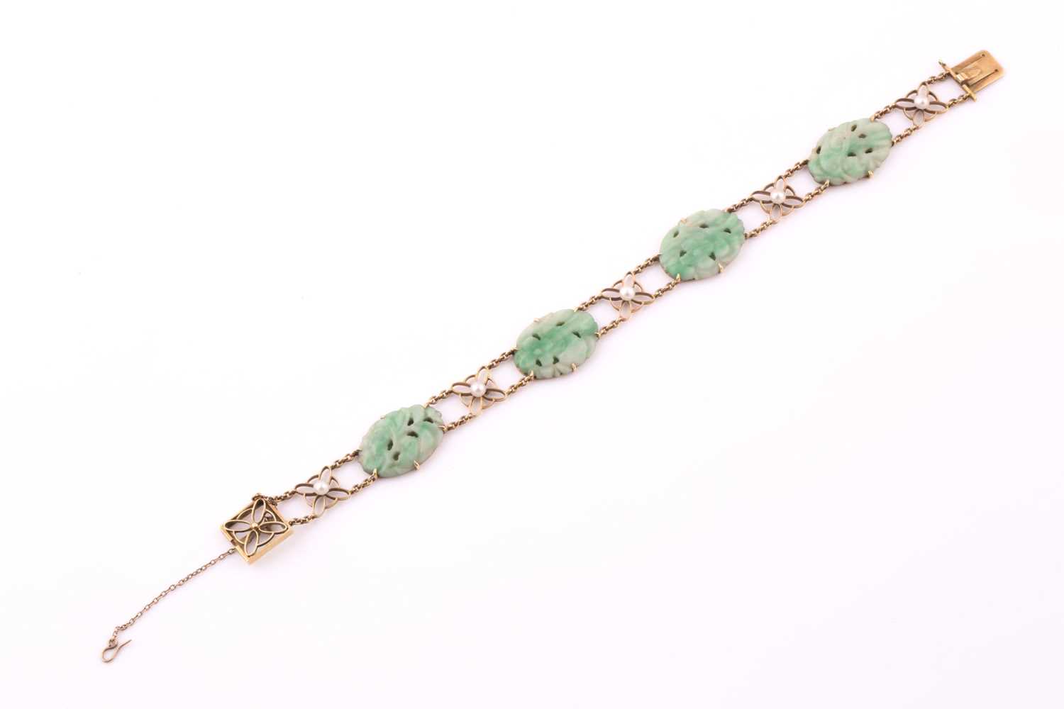 A jade and seed pearl bracelet; comprising four oval carved jade panels set between five foliate