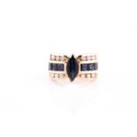 A 14k yellow gold, diamond, and sapphire ring, set with a marquise-cut sapphire, the shoulders