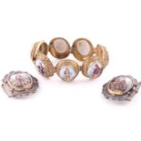 A Victorian gilt metal panel bracelet set with seven oval continental porcelian plaques painted in