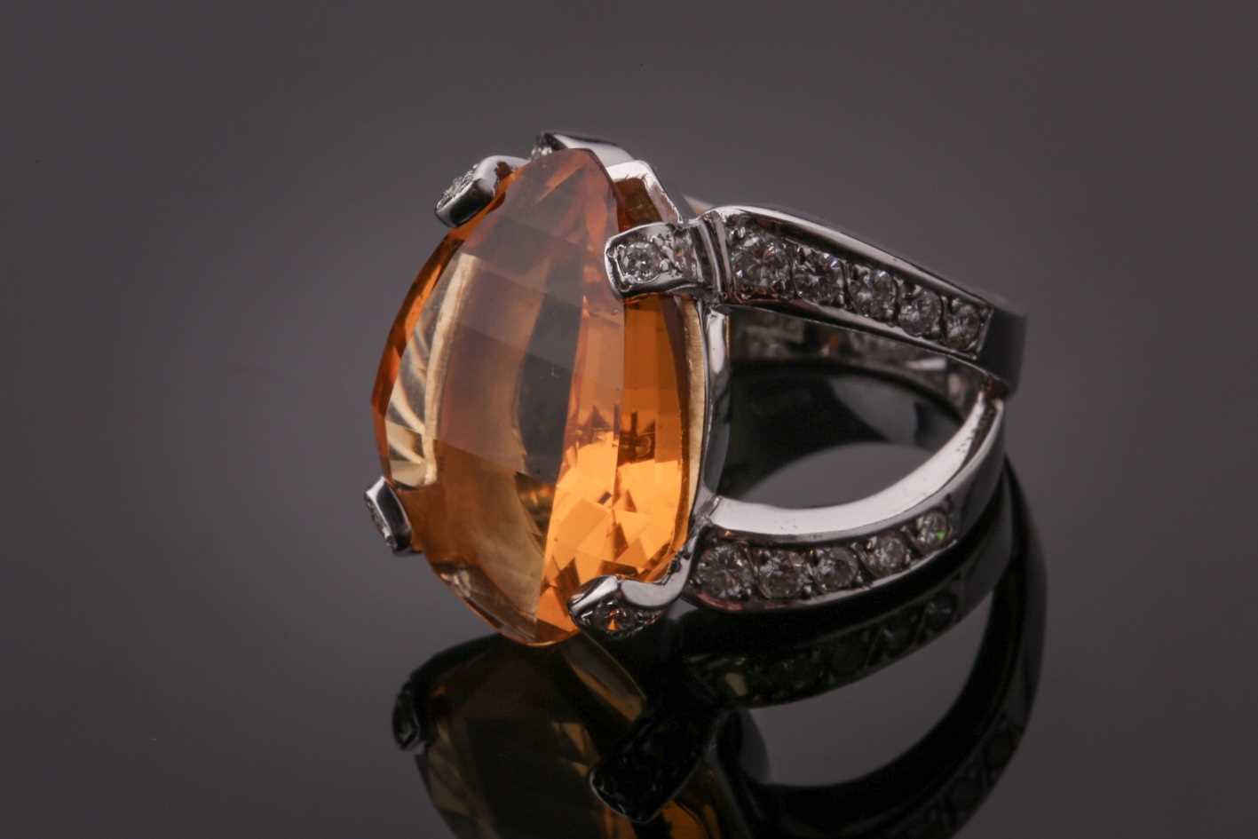 A diamond and citrine cocktail ring, set with a mixed-cut citrine, the claws and split shoulders