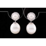 A pair of diamond and pearl drop earrings, each with a cultured pearl within a border of round-cut