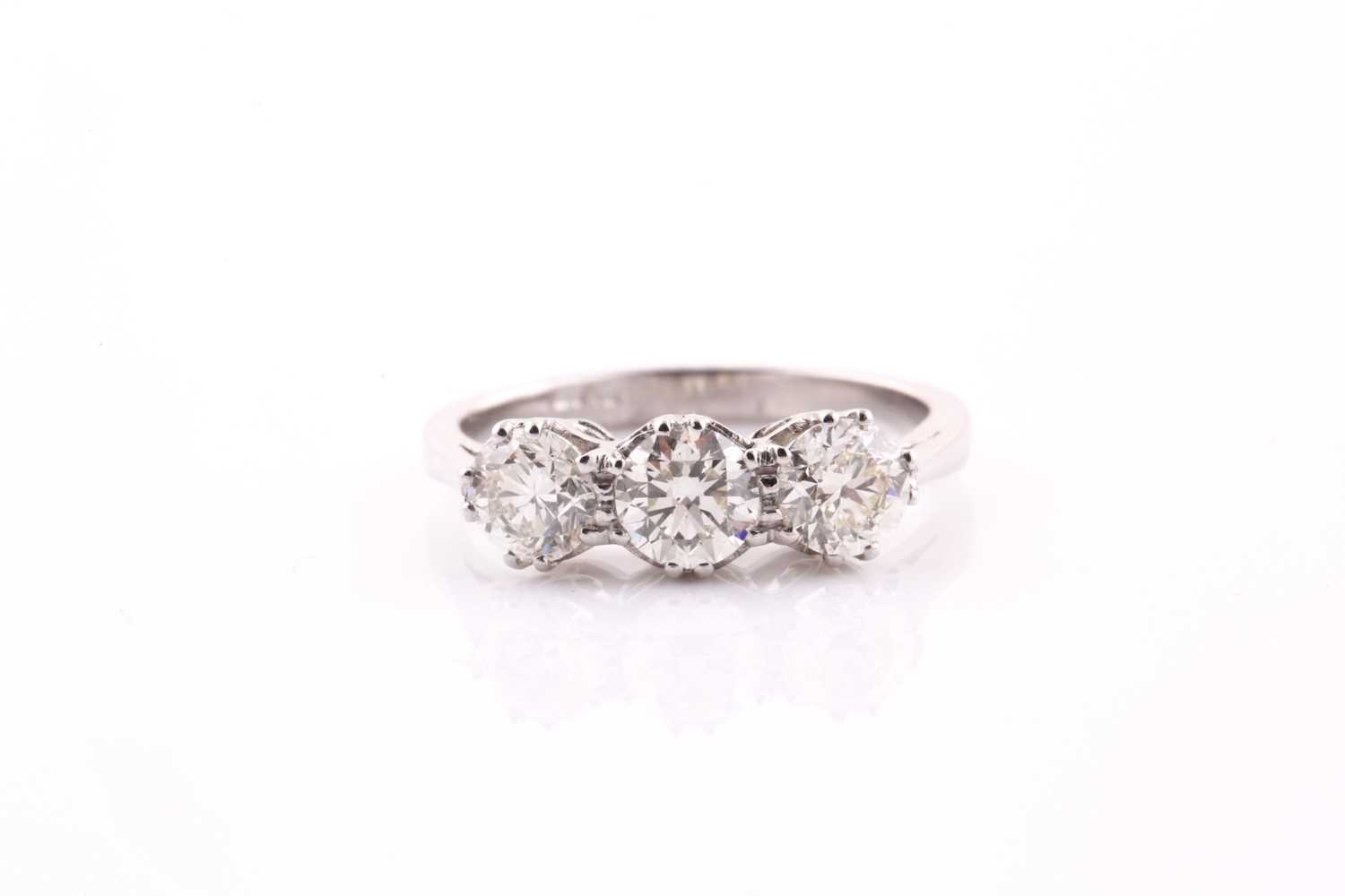 A platinum and diamond ring, set with three round brilliant-cut diamonds of approximately 1.20